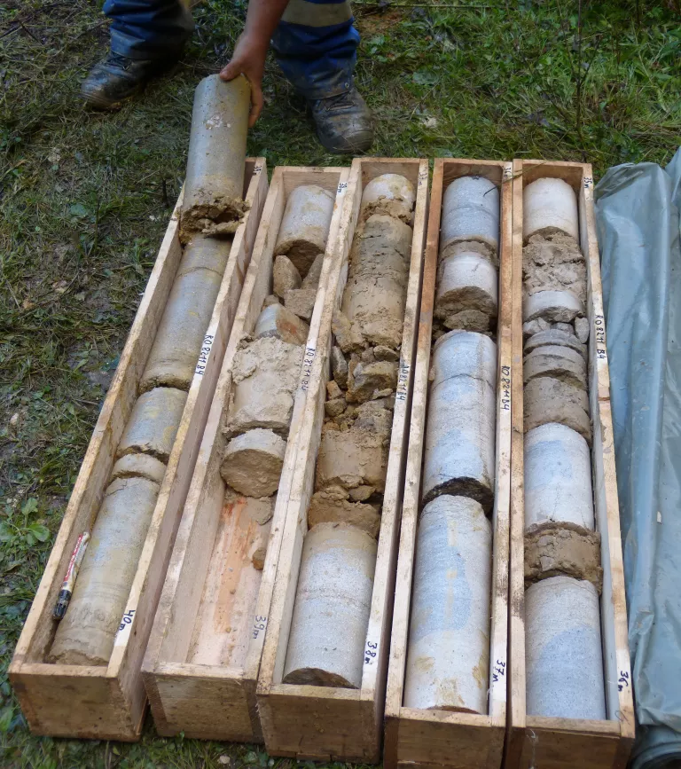 Fünf Holzkisten mit Bohrkernen von je einem Meter Länge und etwa 15 Zentimeter Breite stehen nebeneinander.