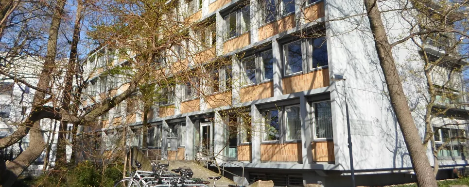 Das Bild zeigt das Hauptgebäude des LGRB in Freiburg. Ein langgezogenes Gebäude mit 4 Stockwerken, Blick Richtung Haupteingang.