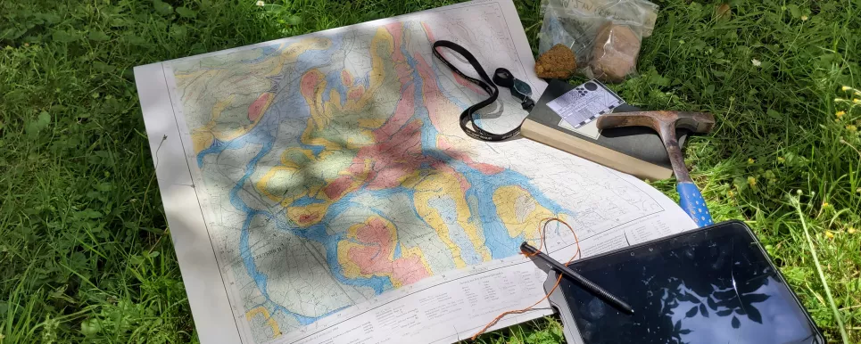 Geologische Karte die in Bearbeitung ist, Gesteinsproben, Feldbuch, Geologenhammer, Tablet
